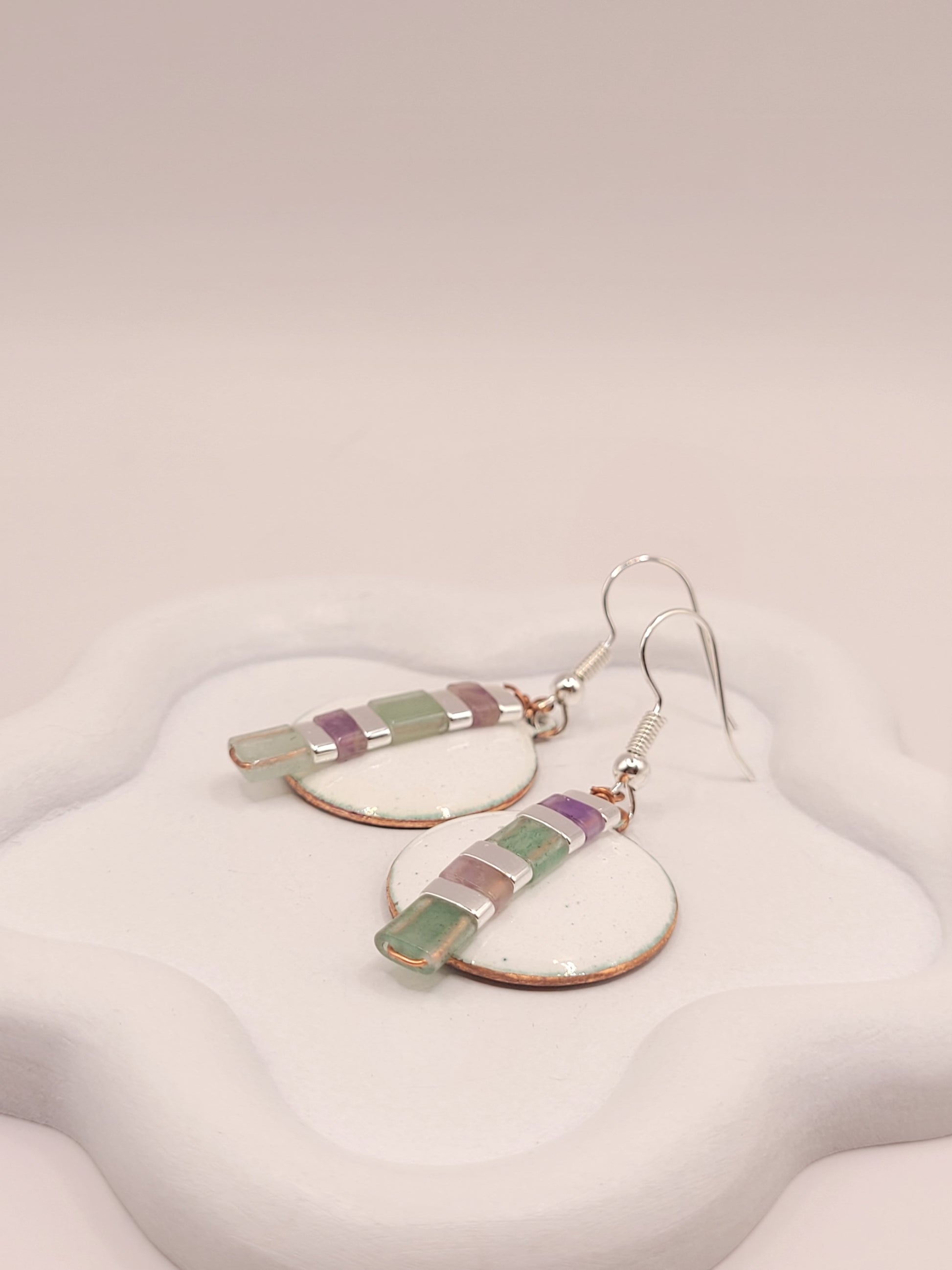 gros plan sur les boucles d'oreilles rondes pendant emaux de la maison CALUB, bijou en email avec perles miyuki