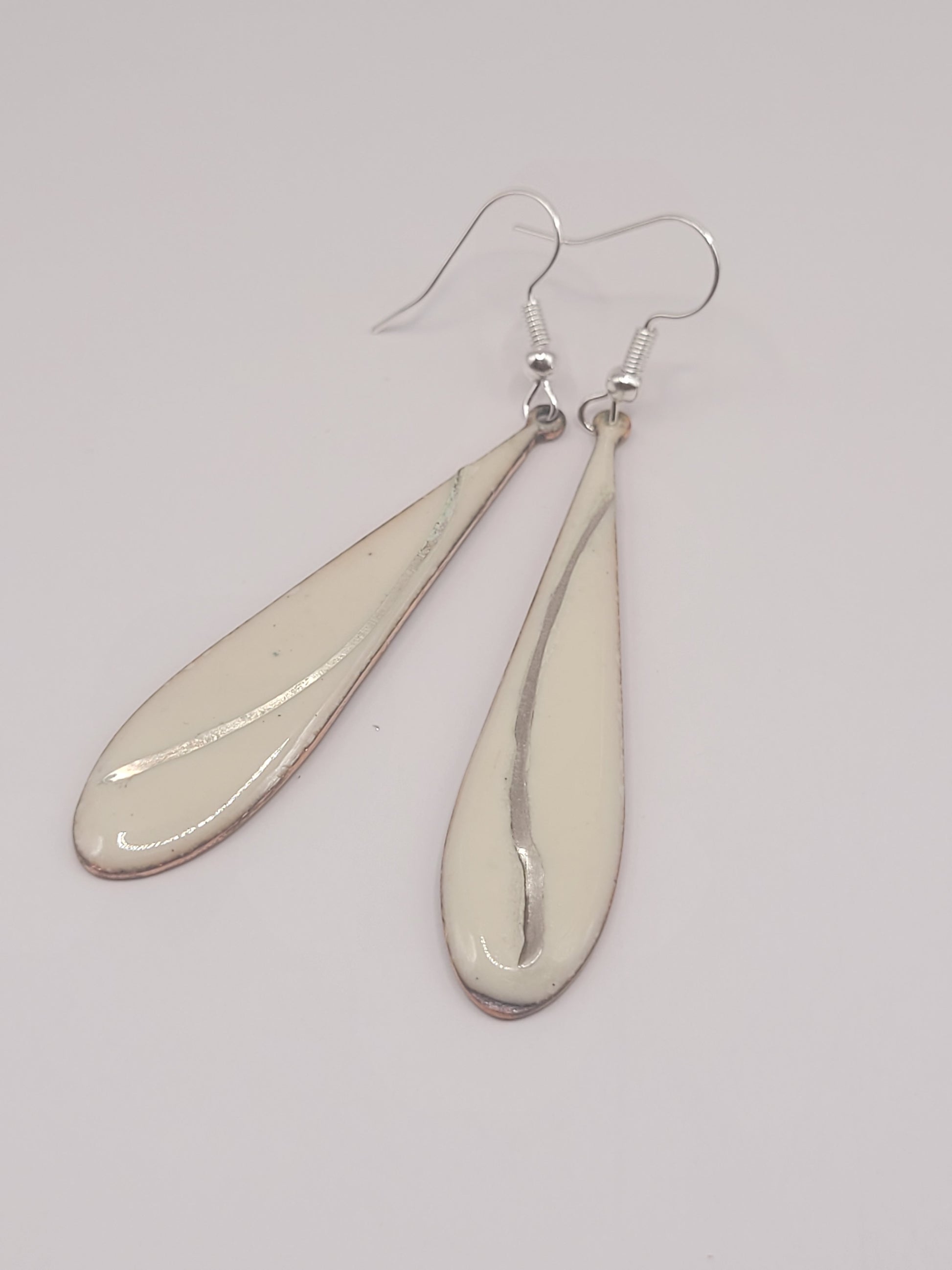 bijou artisanal boucles d'oreilles en email blanc grème avec incrustation d'un fil d'argent. design contemporain sobre et intemporel création maison Calub. Fond blanc