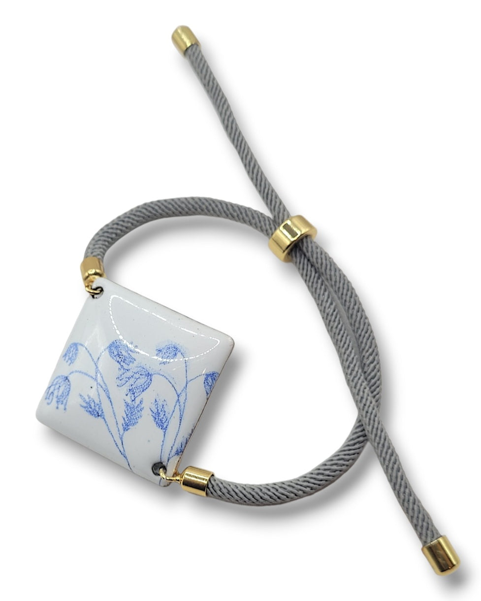 Bracelet cordon en émail sur cuivre de forme carrée. Les motifs bleus sur un émail blanc porcelaine dans la collection Les Uniques chez Maison Calub. Emaux opaques