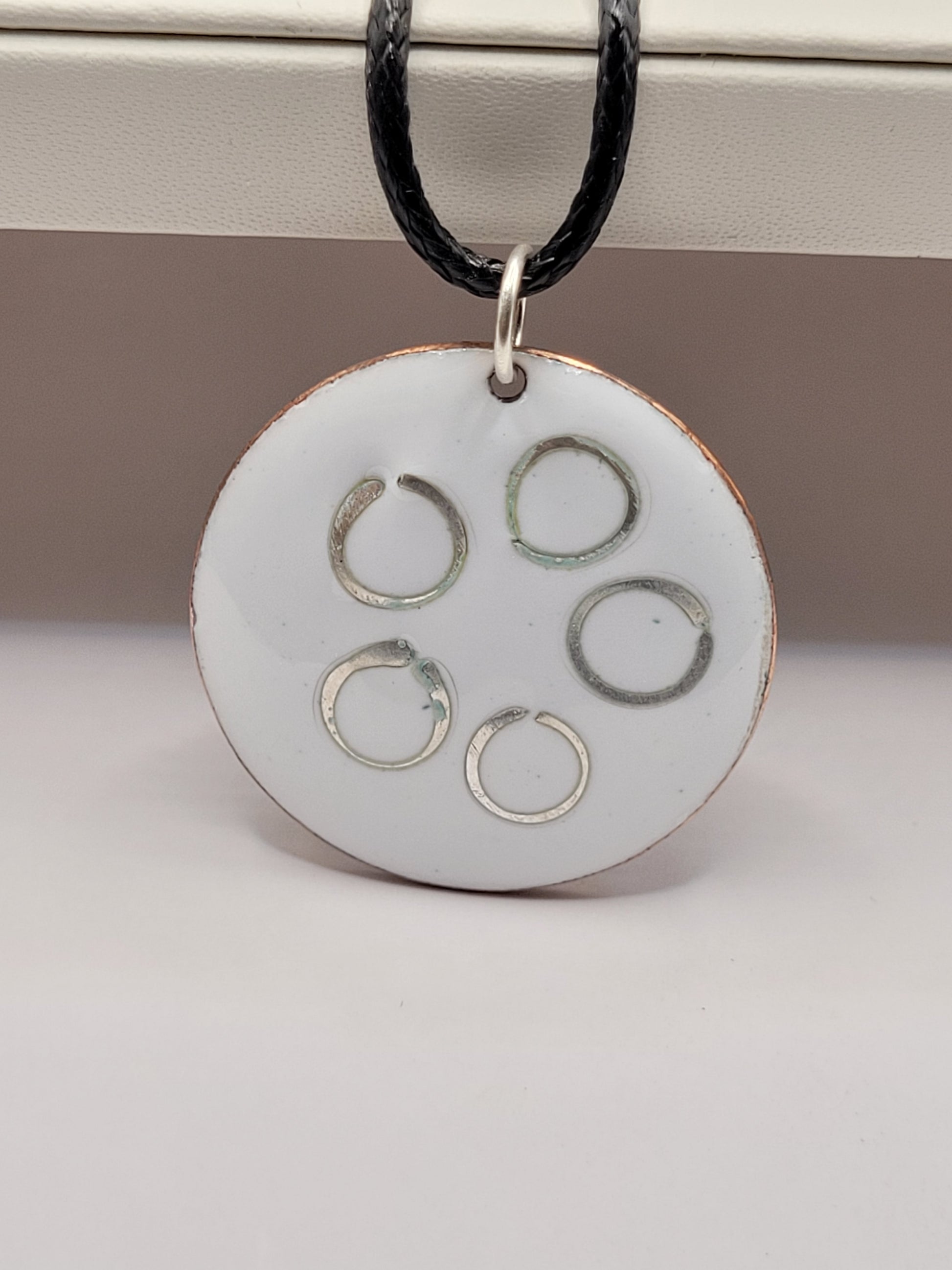 pendentif rond en email sur cuivre avec des anneaux en argent incrustés chez maison calub design contemporain presentoir