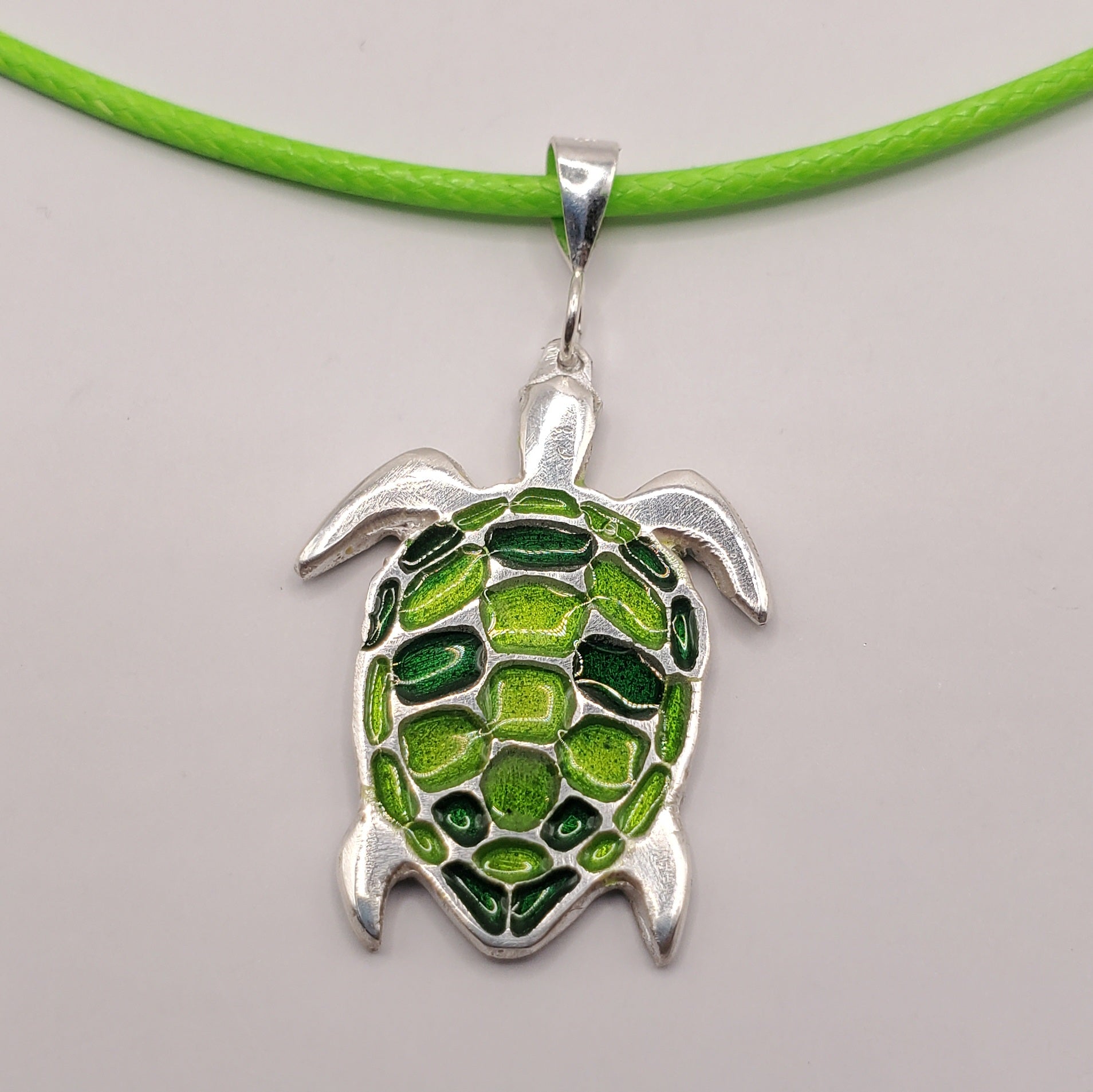 Pendentif email argent porté par une femme, motif tortue de mer