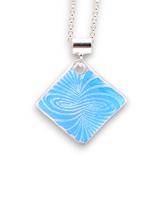 Pendentif basse-taille en émail sur argent fin motif symbolique infini contemporain. Bijou artisanal réalisé à la main chez maison Calub les émaux du Luberon. Email translucide bleu