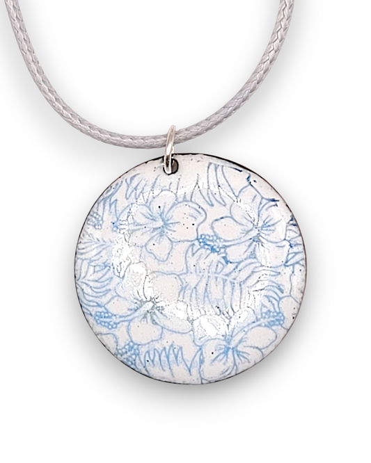 pendentif bleu et blanc aux motifs floraux hibiscus très fins. Emaux traditionnels fait main. Maison Calub émailleur dans le Luberon