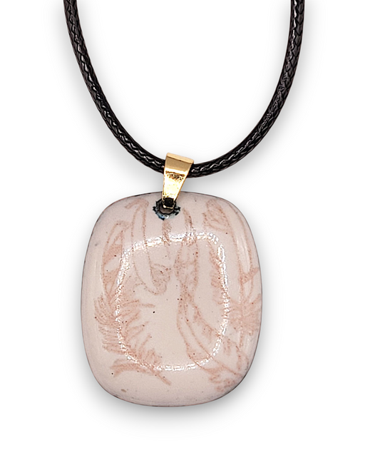 ecolleté au petit pendentif en email sur cuivre crème rosé aux motifs fins de plumes chez maison Calub fond blanc